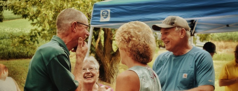Four older people laughing at a party